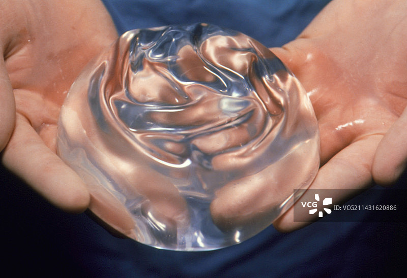 戴手套的手拿着硅胶乳房假体图片素材