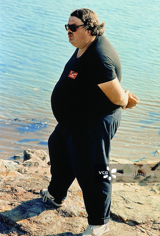 站在水边的肥胖男人图片素材