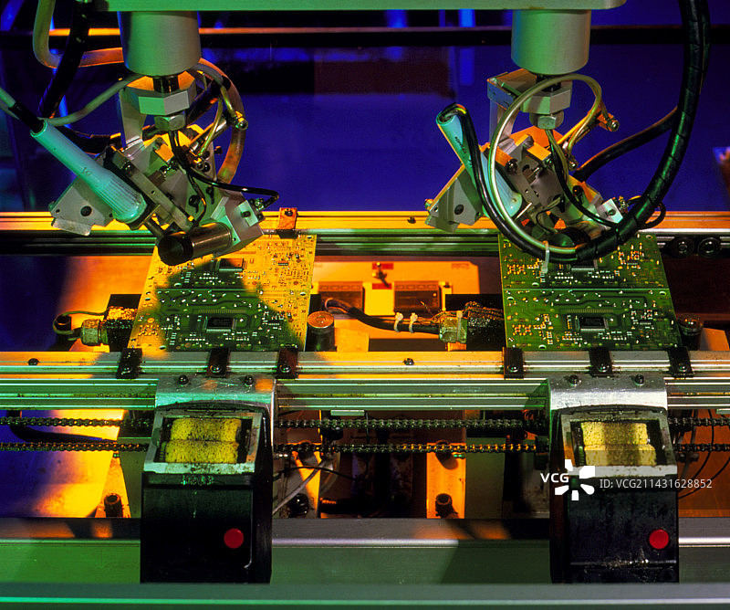 机器人手将元件焊接到电路板上图片素材