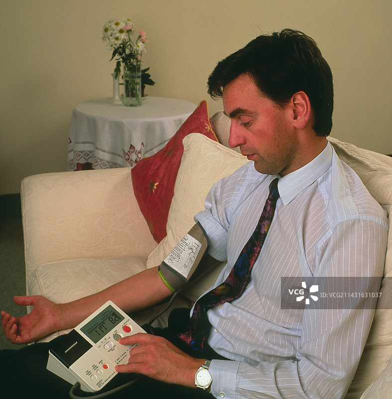男人用电子血压计测量自己的血压图片素材
