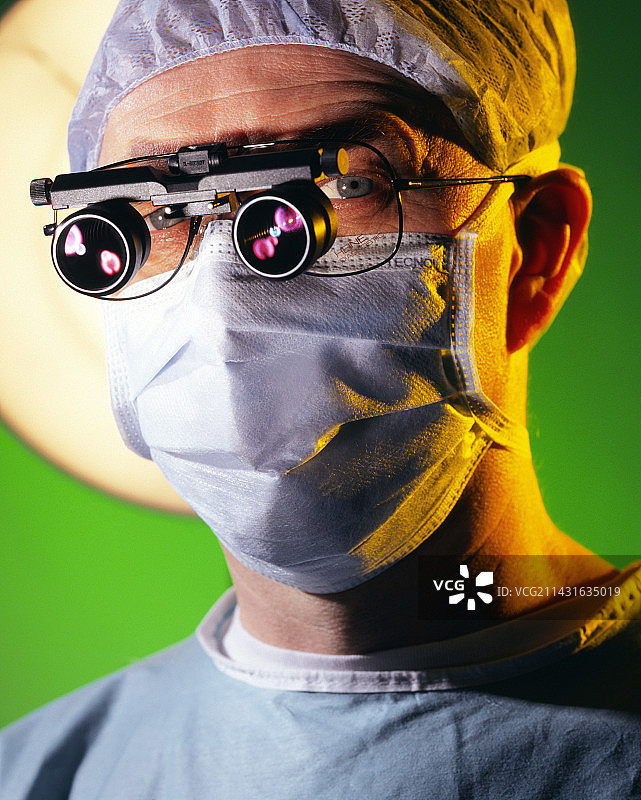 使用放大镜进行显微外科手术的外科医生图片素材
