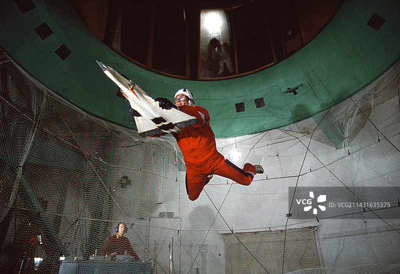 在立式风洞中研究飞机模型的男人图片素材