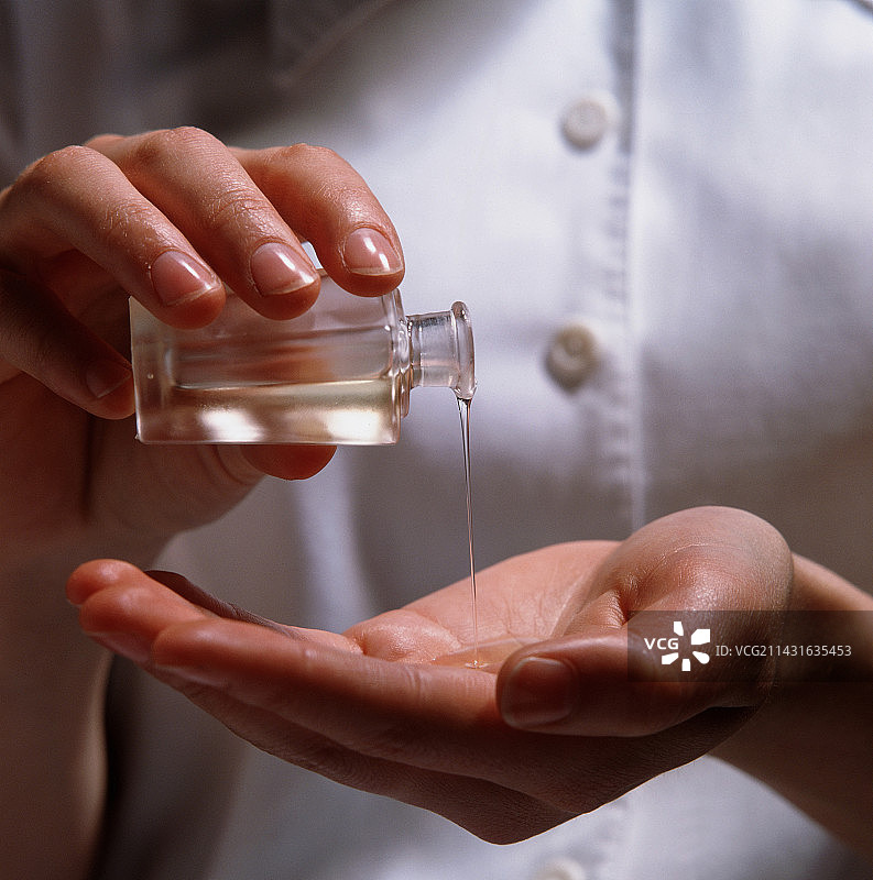 芳香精油倒入手中图片素材