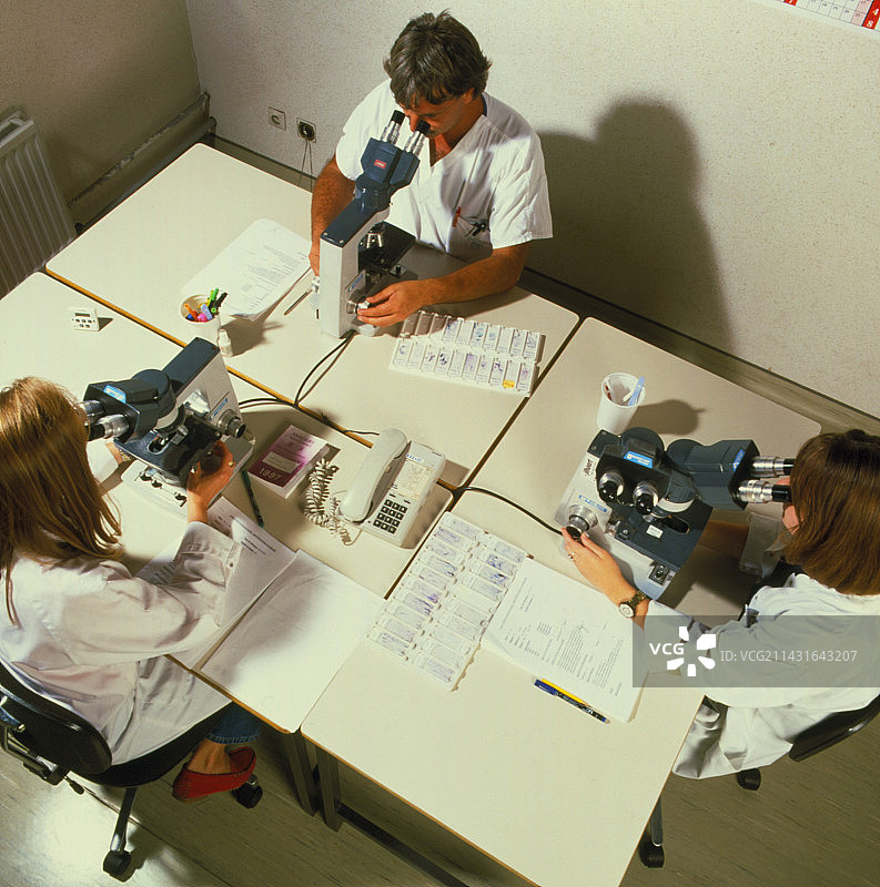 在细胞学实验室使用显微镜的研究员图片素材