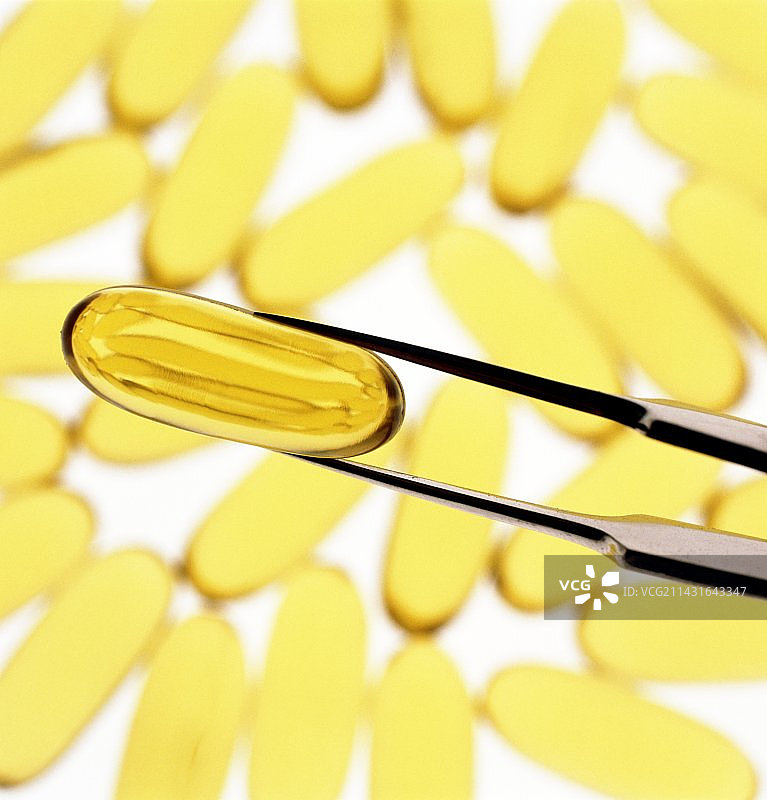 镊子夹着油或维生素E胶囊图片素材