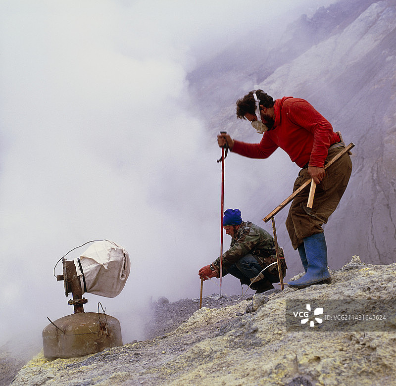 火山学家在火山上采集硫磺样本图片素材