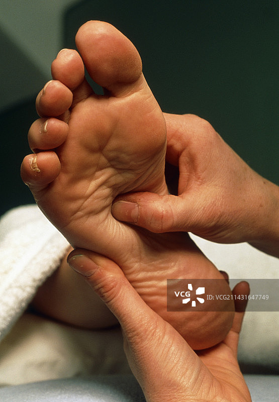 反射疗法按摩师为女性足部按摩图片素材