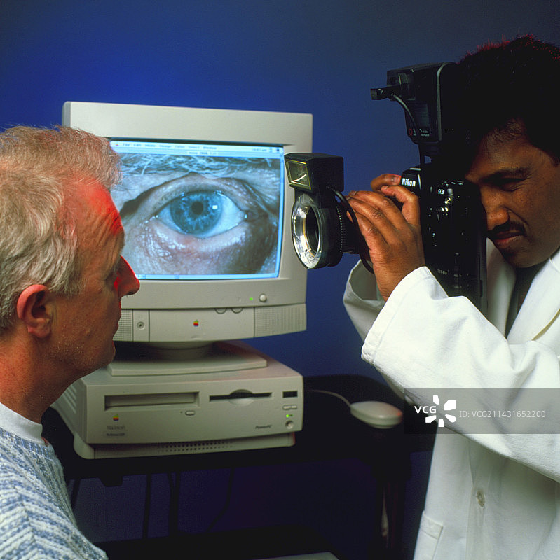 医生拍摄男人的眼睛以作数字记录图片素材