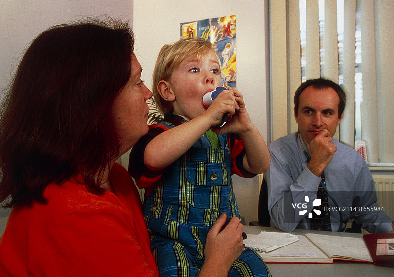 肺功能：男孩对着峰值流量计呼吸图片素材