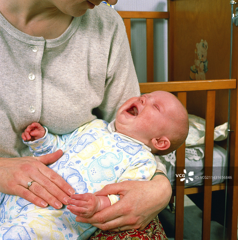 母亲安慰哭泣的四个月大的宝宝图片素材