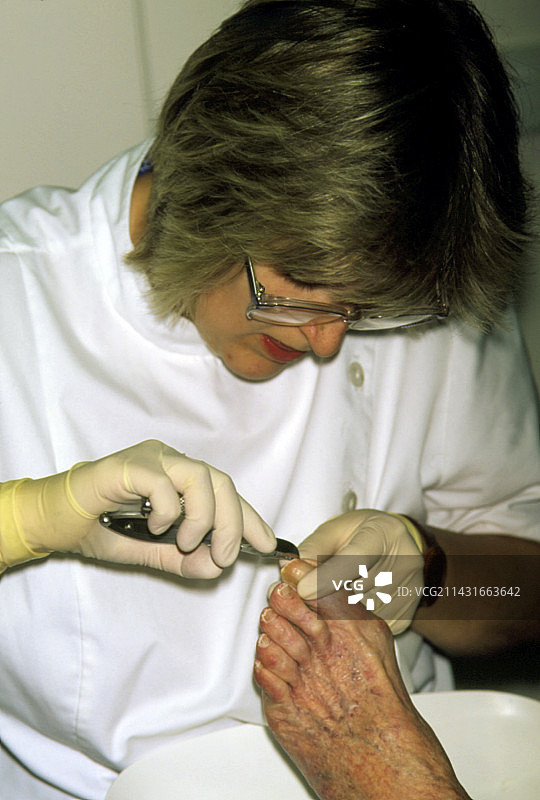 足病医生为老年患者修剪脚趾甲图片素材