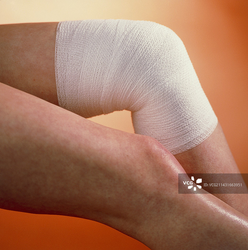 年轻女子缠着绷带的膝盖图片素材