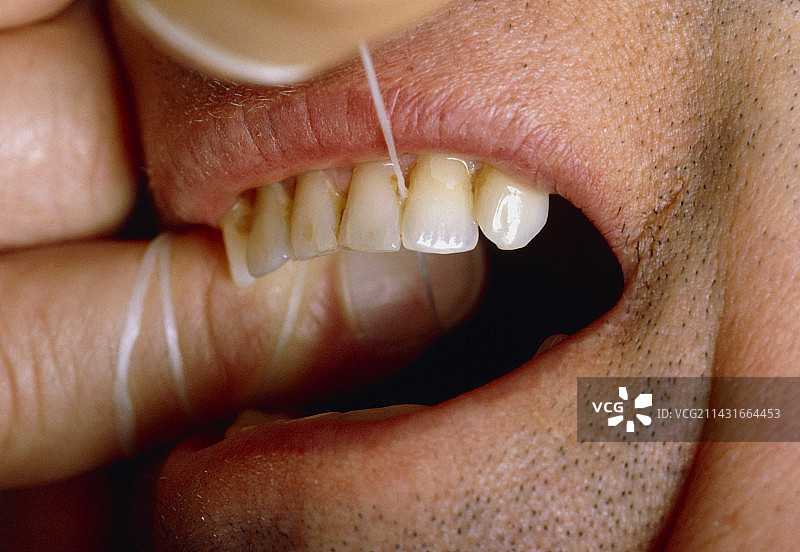 男人用牙线清洁牙齿特写图片素材
