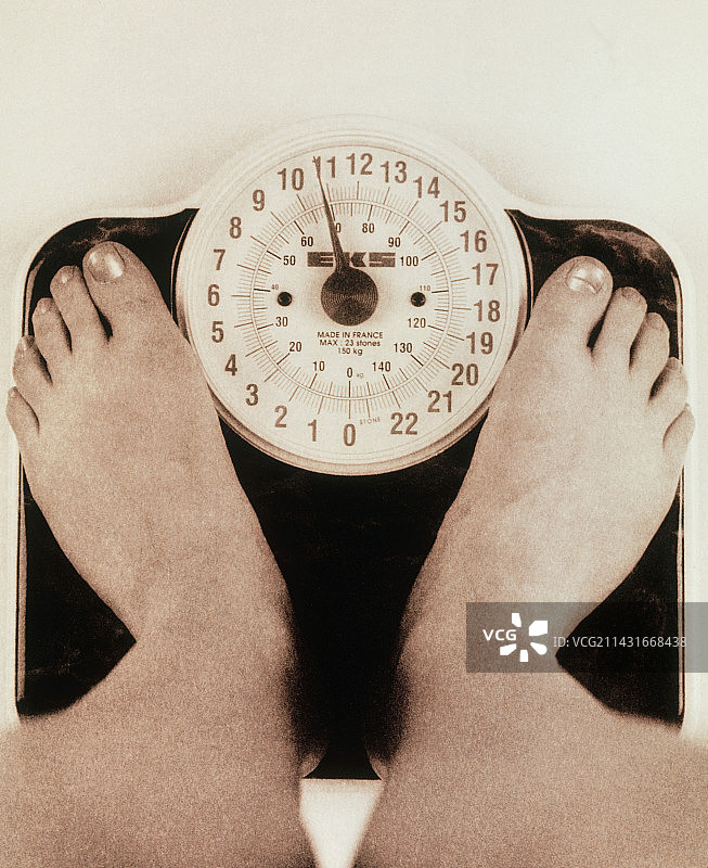 女人站在体重秤上的脚图片素材