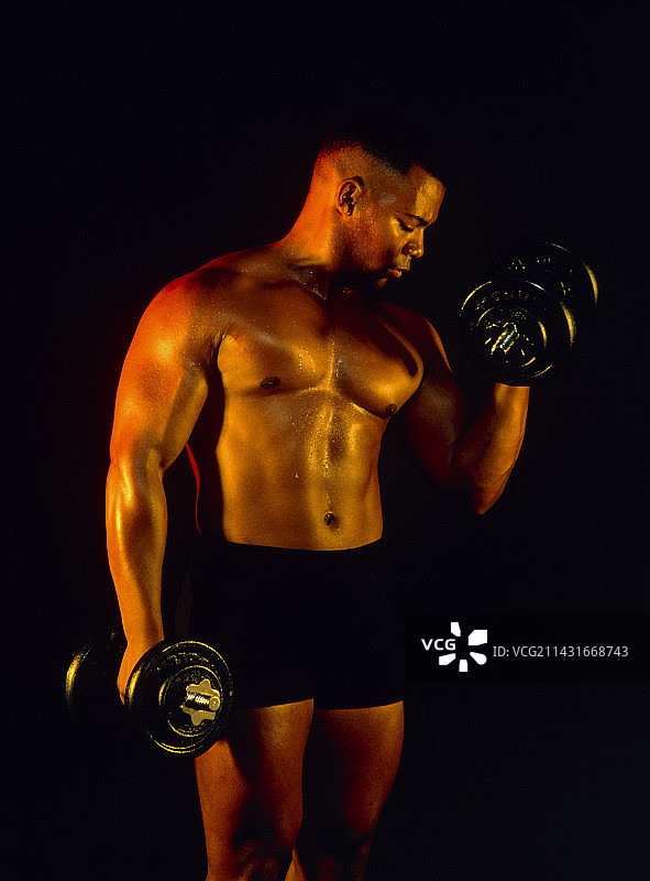 健身：男人用哑铃锻炼肱二头肌图片素材