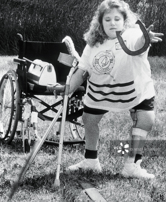 患脊柱裂的年轻女人扔马蹄铁图片素材