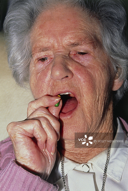 老年妇女吞服处方药胶囊图片素材