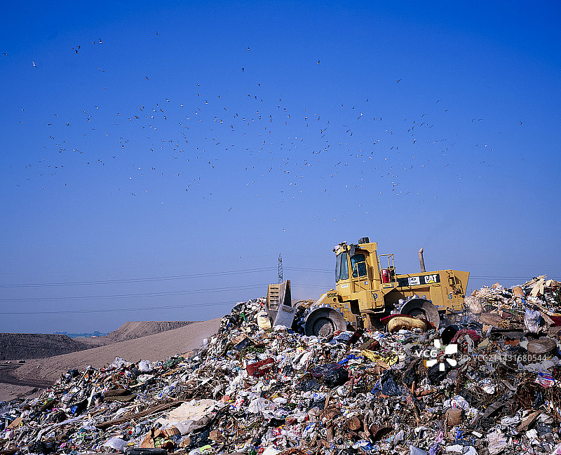 推土机平整垃圾的垃圾填埋场图片素材