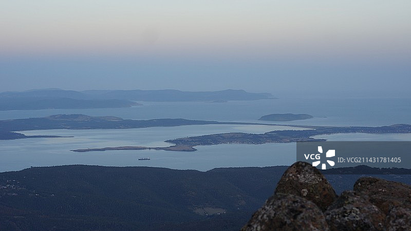 前景是石头 俯瞰山峰与云海 城市与大海图片素材