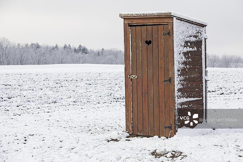 德国萨克森州弗雷塔尔市雪地里带心形门的独立木制厕所图片素材