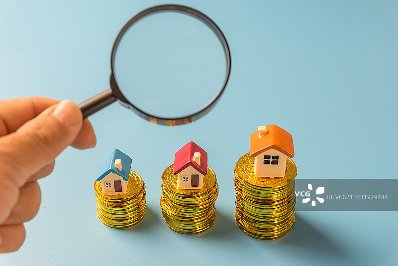 房子模型 堆叠的硬币和放大镜图片素材