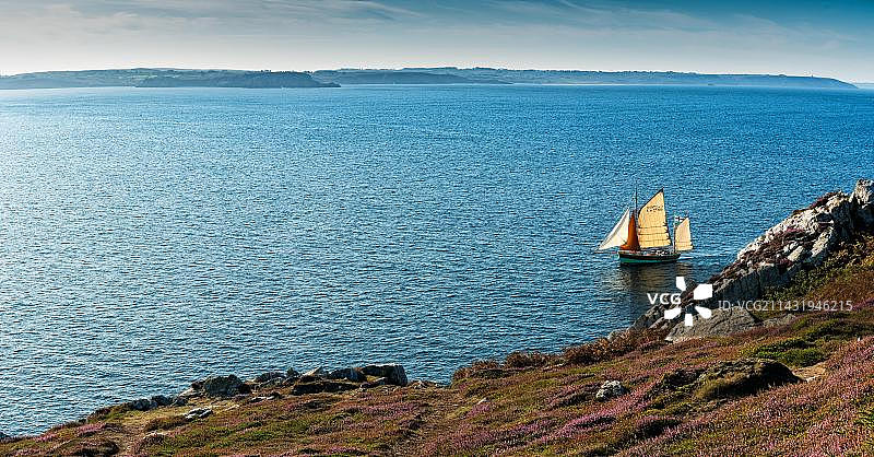 法国布列塔尼岩石海岸旁的木制帆船图片素材