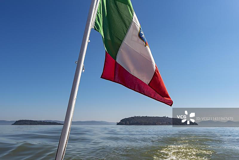 意大利国旗飘扬在特拉西梅诺湖的船上图片素材