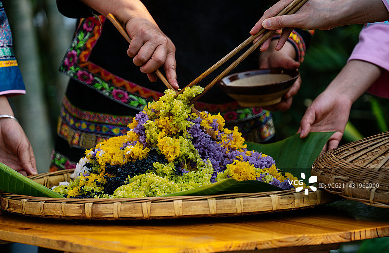 贵州省黔西南布依族苗族自治州望谟县蟠桃街道甘莱村，搅拌五色花糯米饭。图片素材