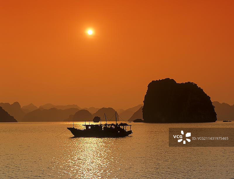 越南下龙湾喀斯特地貌落日下的船只图片素材
