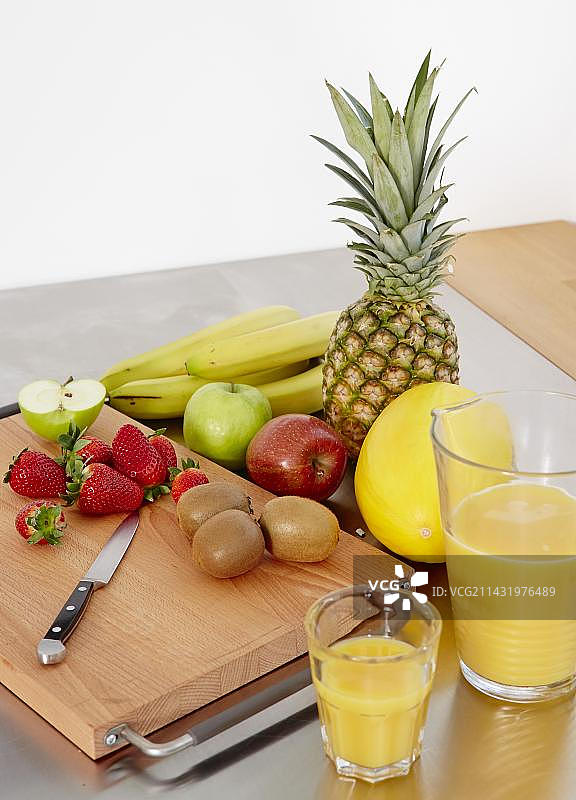 砧板上的各种水果，一侧是橙汁，德国，欧洲图片素材
