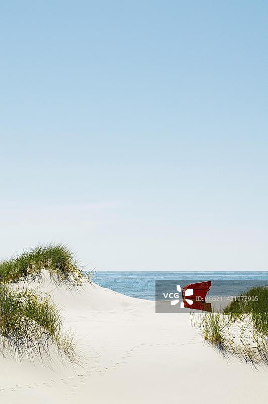 德国石勒苏益格-荷尔斯泰因州阿姆鲁姆海边沙丘上的红色沙滩椅图片素材