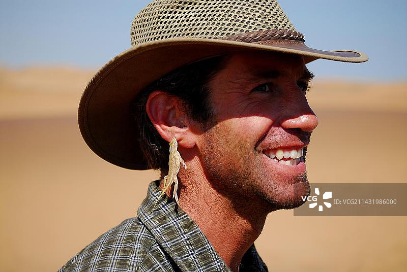 在纳米比亚斯瓦科普蒙德附近，一只铲鼻蜥蜴/潜沙蜥蜴咬了一个人的耳朵图片素材