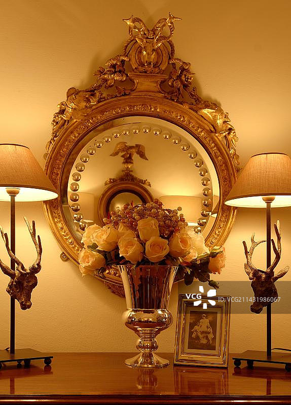 花瓶里的人造花，置于金色镜框前图片素材