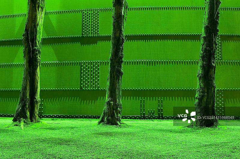 德国北莱茵-威斯特法伦州杜伊斯堡北部景观公园的绿色灯光树干和钢墙图片素材