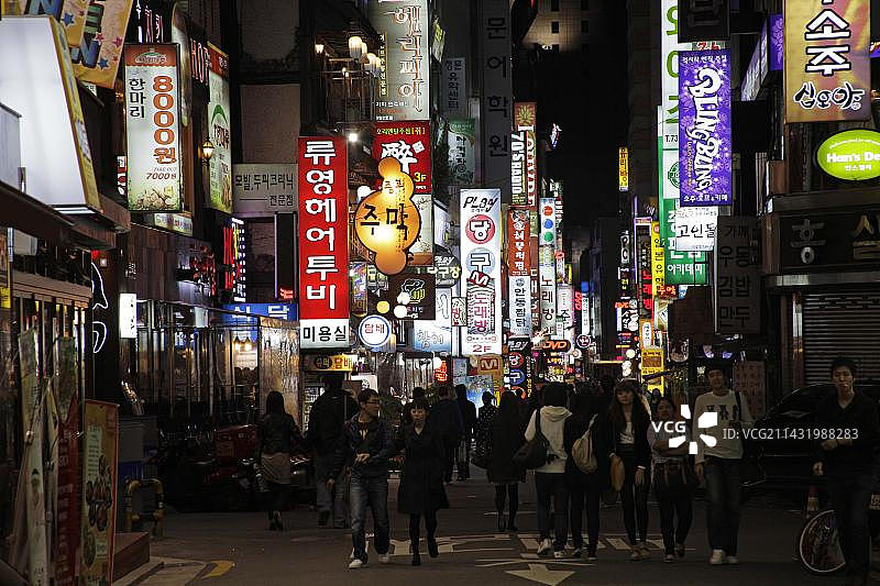 在韩国首尔娱乐区傍晚漫步的年轻韩国人图片素材