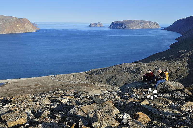 徒步者俯瞰加拿大努纳武特巴芬岛的阳光峡湾，位于北美洲北极地区图片素材