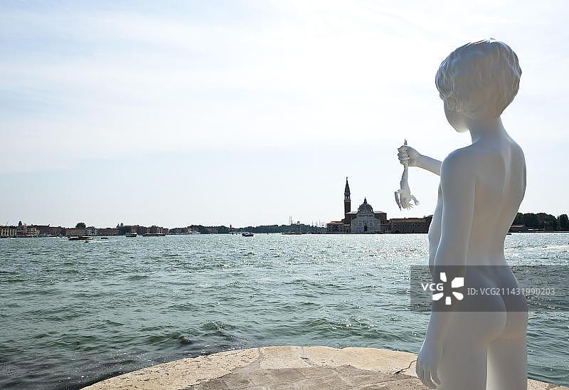 意大利威尼斯海关大楼的雕塑：查尔斯·雷创作的抱蛙男孩图片素材