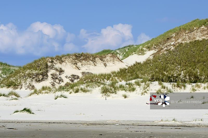 游客在德国阿姆鲁姆岛Kniepsand海滩的沙丘上享受阳光图片素材