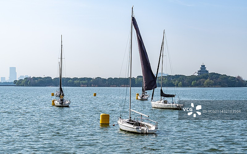 雾色天空下的江苏苏州金鸡湖桃花岛湖泊帆船游船景观图片素材