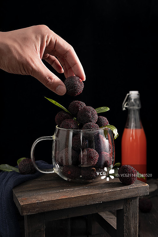 手拿一颗夏季新鲜杨梅图片素材