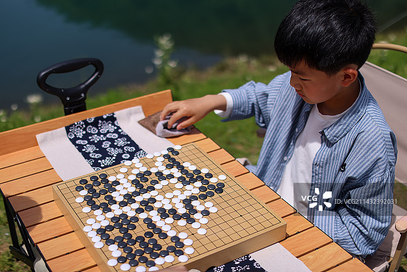 正在野外下棋的中国小男孩图片素材
