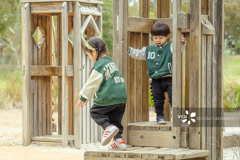 两个小孩在树林亭子中玩追逐游戏图片素材