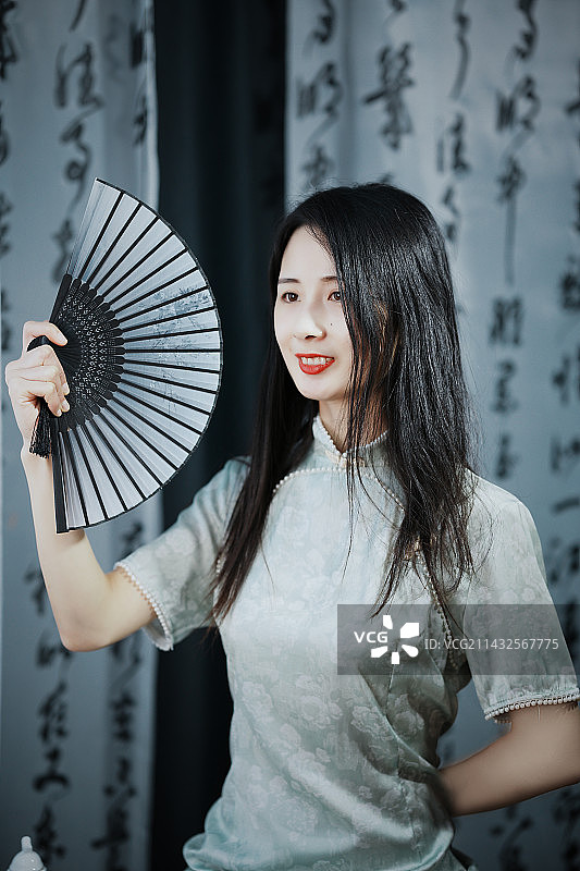 微笑的年轻女子手持扇子的画像图片素材