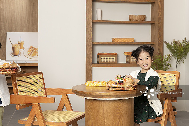 坐在小圆桌前的小女孩图片素材
