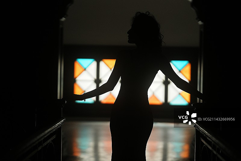 站在窗边的女人的剪影图片素材