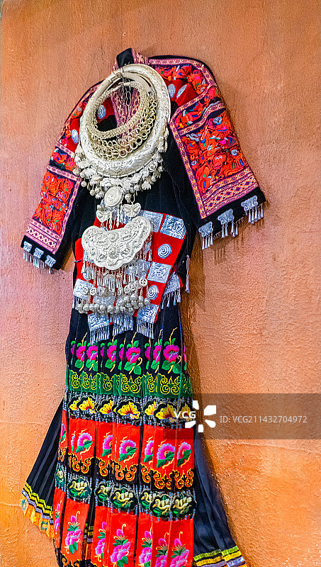 中国少数民族服装拍摄主题，墙上悬挂的云南阿瓦族民族服饰，户外白昼无人图像摄影图片素材
