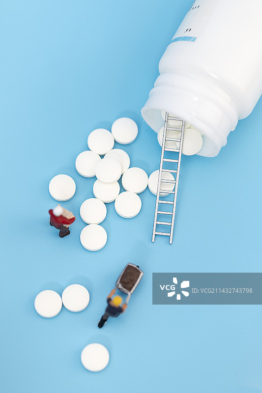 白色药片微缩创意蓝色背景图片素材