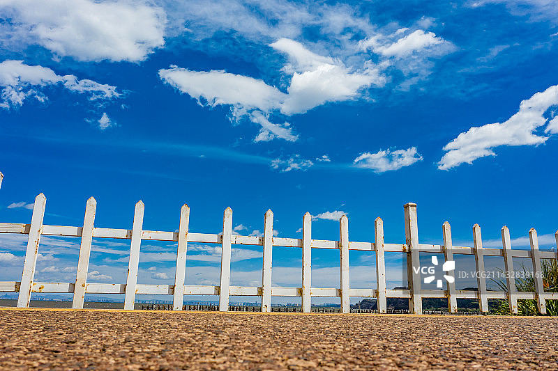 航拍云南昆明古滇精品湿地公园 蓝天白云下的园林栏杆 人行道白色护栏图片素材