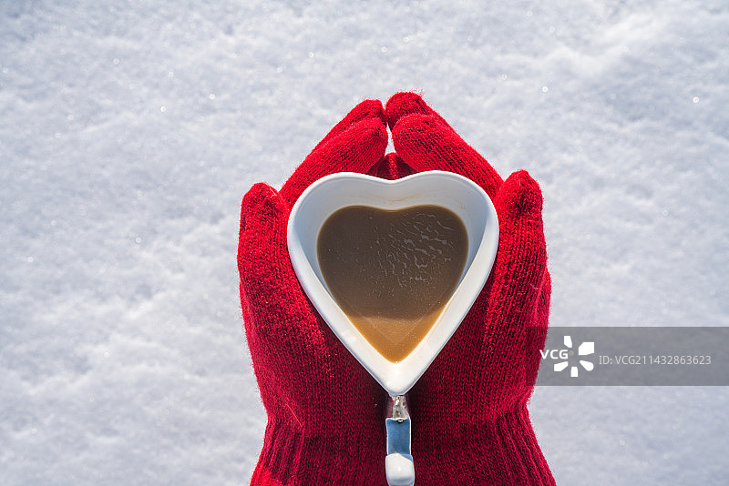女孩戴着红色的手套捧着一杯咖啡图片素材