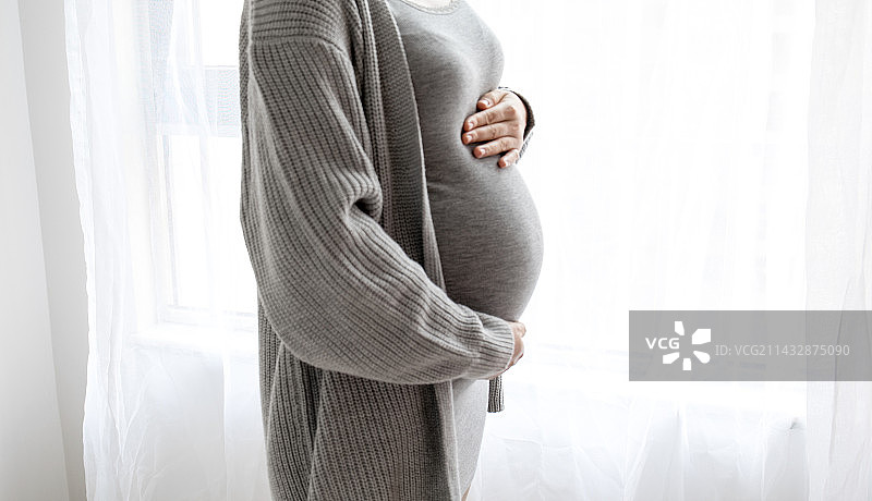 年轻孕妇手放在肚子上图片素材
